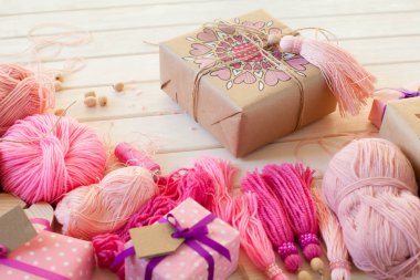 Pembe püsküllü. Beyaz ahşap arka plan. Kadın el sanatları. Yaratıcılık kavramı.