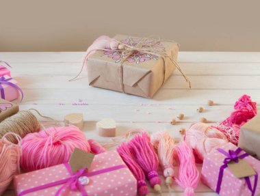 Pembe püsküllü. Beyaz ahşap arka plan. Kadın el sanatları. Yaratıcılık kavramı.