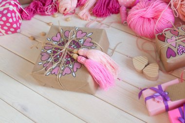 Pembe püsküllü. Beyaz ahşap arka plan. Kadın el sanatları. Yaratıcılık kavramı.