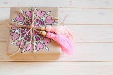 Pembe püsküllü. Beyaz ahşap arka plan. Kadın el sanatları. Yaratıcılık kavramı.