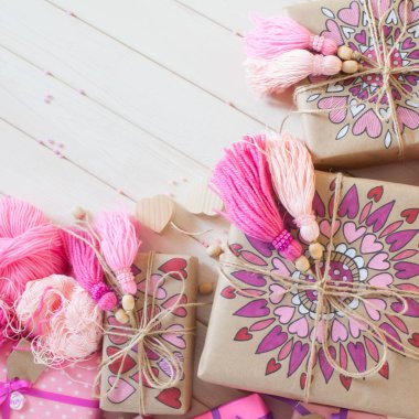 Pembe püsküllü. Beyaz ahşap arka plan. Kadın el sanatları. Yaratıcılık kavramı.