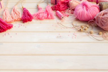 Pembe püsküllü. Arka plan beyaz ahşap.