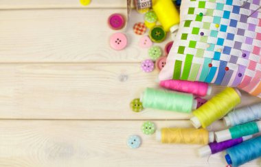 Dikiş aksesuarları beyaz bir arka plan üzerinde yalan. Ölçüm bandı, iplik, kumaş, İğne mili ve iğneler dikiş için.