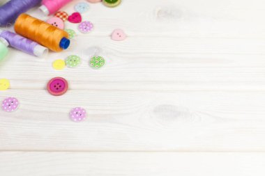 Dikiş aksesuarları beyaz bir arka plan üzerinde yalan. Ölçüm bandı, iplik, kumaş, İğne mili ve iğneler dikiş için.