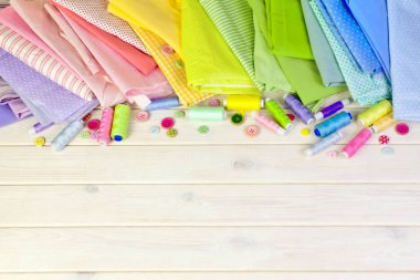 Dikiş aksesuarları beyaz bir arka plan üzerinde yalan. Ölçüm bandı, iplik, kumaş, İğne mili ve iğneler dikiş için.