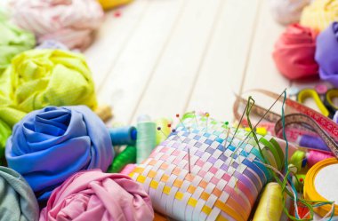 Dikiş aksesuarları beyaz bir arka plan üzerinde yalan. Ölçüm bandı, iplik, kumaş, İğne mili ve iğneler dikiş için.