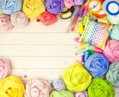 Dikiş aksesuarları beyaz bir arka plan üzerinde yalan. Ölçüm bandı, iplik, kumaş, İğne mili ve iğneler dikiş için.