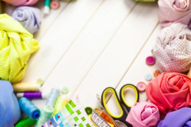 Dikiş aksesuarları beyaz bir arka plan üzerinde yalan. Ölçüm bandı, iplik, kumaş, İğne mili ve iğneler dikiş için.