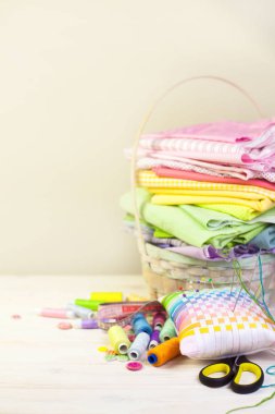 Dikiş aksesuarları beyaz bir arka plan üzerinde yalan. Ölçüm bandı, iplik, kumaş, İğne mili ve iğneler dikiş için.