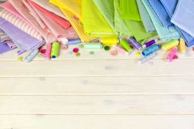 Dikiş aksesuarları beyaz bir arka plan üzerinde yalan. Ölçüm bandı, iplik, kumaş, İğne mili ve iğneler dikiş için.