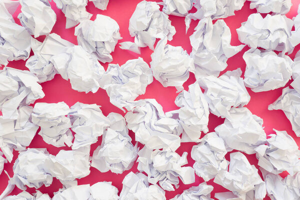 Pile of crumpled paper on a colored background.