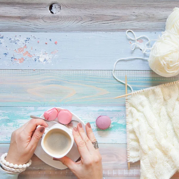 Örgü örgü iğne ile. Beyaz kumaş örme. Kahve Americano. Arka plan ışığı yaşlı.