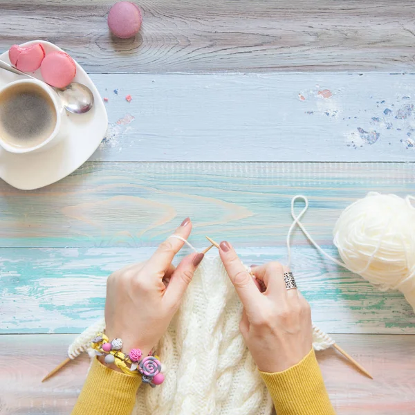 Örgü örgü iğne ile. Beyaz kumaş örme. Kahve Americano. Arka plan ışığı yaşlı.