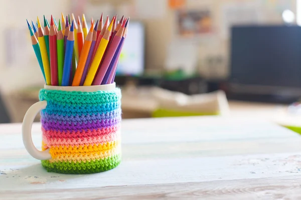 Colored pencils in a pencil case on workspace and workshop background