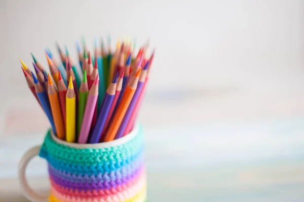 Colored pencils in a pencil case on workspace and workshop background