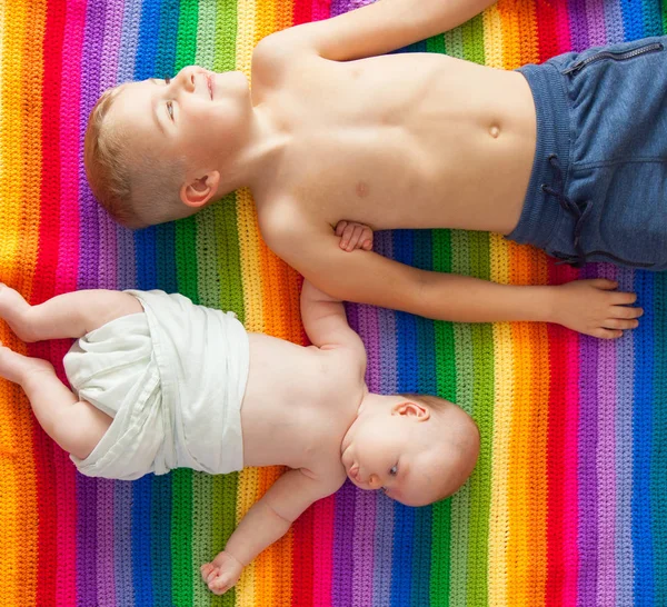 Chłopcy Kłamstwa Uśmiechając Się Trzymając Się Ręce Rainbow Koc Braci — Zdjęcie stockowe