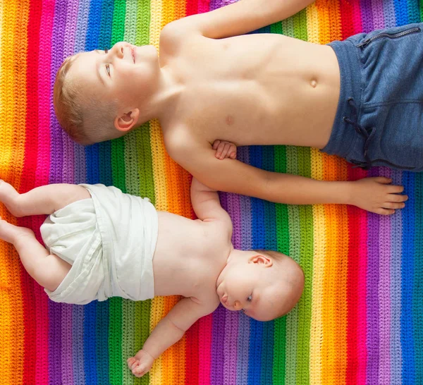 Boys Lying Smiling Holding Hands Rainbow Blanket Brothers Older Younger — Stock Photo, Image