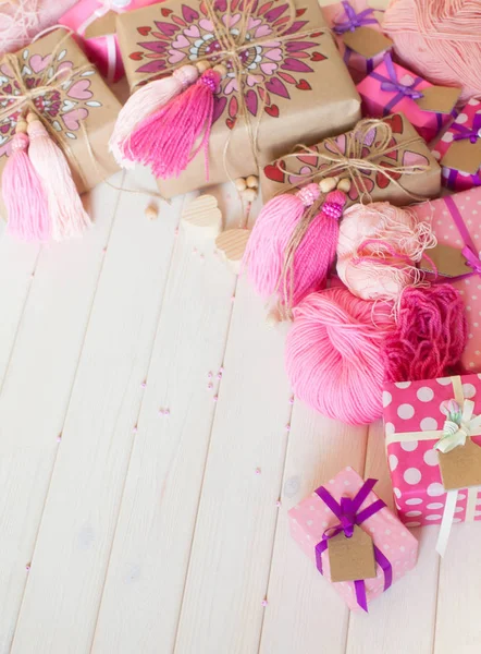 Pembe püsküllü. Beyaz ahşap arka plan. Kadın el sanatları. Yaratıcılık kavramı.