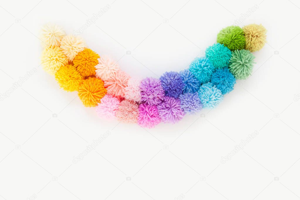 Garland and a wreath of colored pompons. Bright yarn pastel colors.
