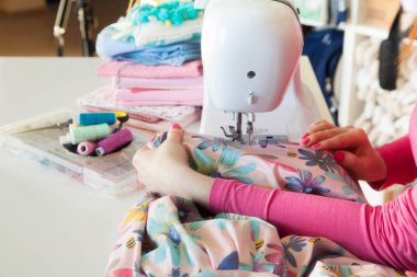 Çalışırken dikiş diken genç bir kadın.