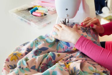 Çalışırken dikiş diken genç bir kadın.