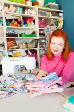 Çalışırken dikiş diken genç bir kadın.