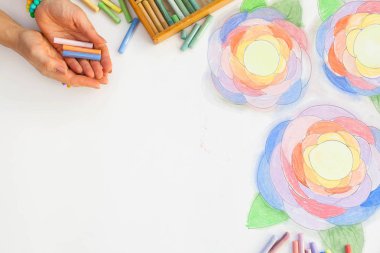 Çiçekler pastel ile çizilmiş sanat. Kalem, işaretleri ve beyaz bir arka plan üzerinde sanatçının eller.