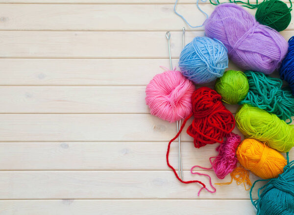 Женщина с татуировкой в виде шара шерсти держит скейн. Фон из белого дерева
.