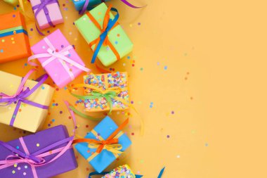 Renkli hediye kutuları renkli şeritler. Sarı arka plan. Noel veya doğum günü için hediyeler.