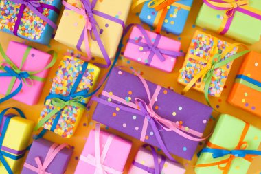 Renkli hediye kutuları renkli şeritler. Sarı arka plan. Noel veya doğum günü için hediyeler.