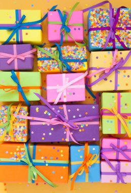 Renkli hediye kutuları renkli şeritler. Sarı arka plan. Noel veya doğum günü için hediyeler.