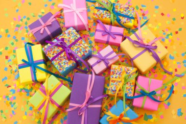 Renkli hediye kutuları renkli şeritler. Sarı arka plan. Noel veya doğum günü için hediyeler.