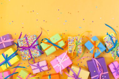 Renkli hediye kutuları renkli şeritler. Sarı arka plan. Noel veya doğum günü için hediyeler.