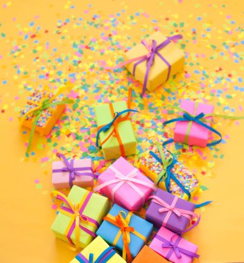 Renkli hediye kutuları renkli şeritler. Sarı arka plan. Noel veya doğum günü için hediyeler.