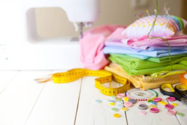 Beyaz bir arka plan üzerinde renkli kumaş Rulolar. Bir tabak üzerinde renkli iplik ile Makaralar. Beyaz arka plan. Yukarıdan görüntüle.