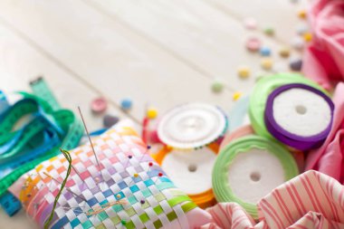 Beyaz bir arka plan üzerinde renkli kumaş Rulolar. Bir tabak üzerinde renkli iplik ile Makaralar. Beyaz arka plan. Yukarıdan görüntüle.