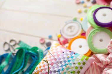 Beyaz bir arka plan üzerinde renkli kumaş Rulolar. Bir tabak üzerinde renkli iplik ile Makaralar. Beyaz arka plan. Yukarıdan görüntüle.