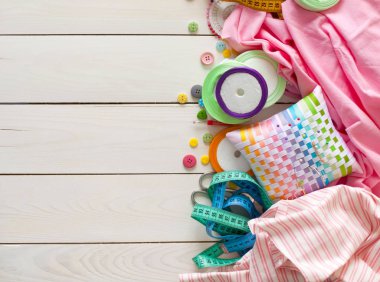 Beyaz bir arka plan üzerinde renkli kumaş Rulolar. Bir tabak üzerinde renkli iplik ile Makaralar. Beyaz arka plan. Yukarıdan görüntüle.