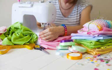 Beyaz bir arka plan üzerinde renkli kumaş Rulolar. Bir tabak üzerinde renkli iplik ile Makaralar. Beyaz arka plan. Yukarıdan görüntüle.