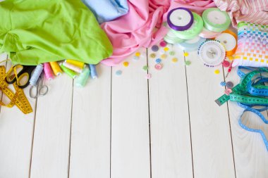 Beyaz bir arka plan üzerinde renkli kumaş Rulolar. Bir tabak üzerinde renkli iplik ile Makaralar. Beyaz arka plan. Yukarıdan görüntüle.