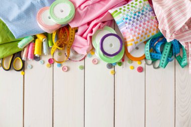 Beyaz bir arka plan üzerinde renkli kumaş Rulolar. Bir tabak üzerinde renkli iplik ile Makaralar. Beyaz arka plan. Yukarıdan görüntüle.