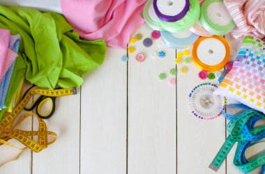 Beyaz bir arka plan üzerinde renkli kumaş Rulolar. Bir tabak üzerinde renkli iplik ile Makaralar. Beyaz arka plan. Yukarıdan görüntüle.