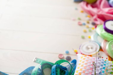 Beyaz bir arka plan üzerinde renkli kumaş Rulolar. Bir tabak üzerinde renkli iplik ile Makaralar. Beyaz arka plan. Yukarıdan görüntüle.