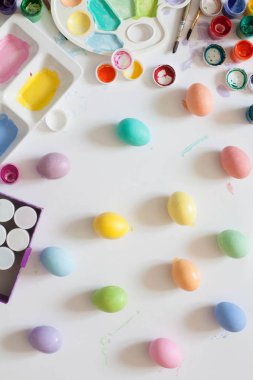 Ahşap tahta arka plan ile yer üzerinde pastel renkli Paskalya yumurtaları.