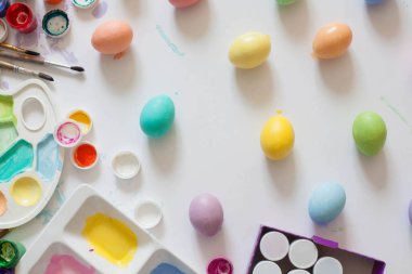 Ahşap tahta arka plan ile yer üzerinde pastel renkli Paskalya yumurtaları.