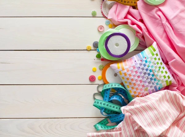 Beyaz bir arka plan üzerinde renkli kumaş Rulolar. Bir tabak üzerinde renkli iplik ile Makaralar. Beyaz arka plan. Yukarıdan görüntüle.