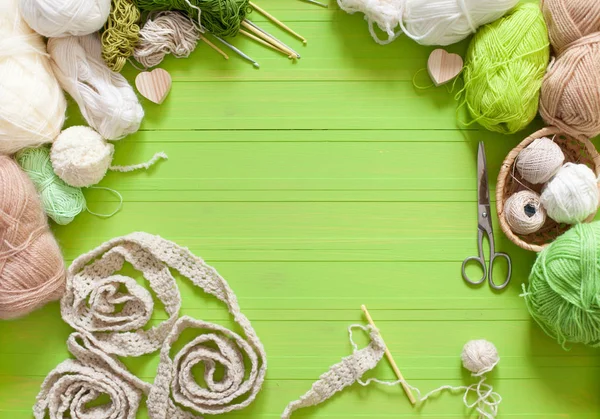 緑の背景にウール糸の自然な色合いのハンクス — ストック写真