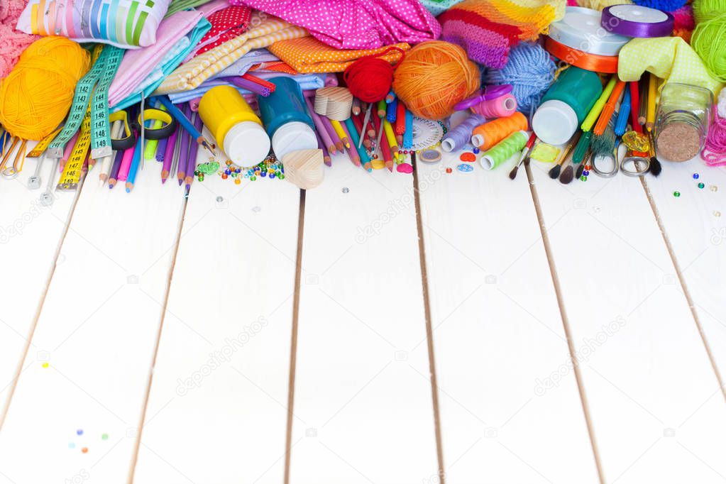 Colored fabric, yarn, thread, crayons and paints. Colored materials for creative work on the table. Do needlework. Everything for handmade.