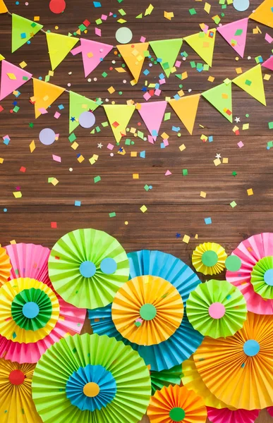 Colored flags garlands and rosettes on wooden background