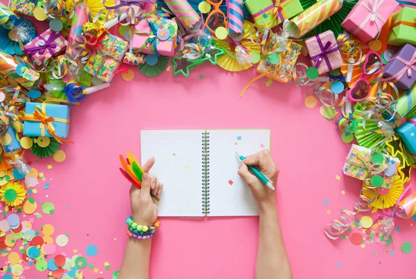Mujer Escribiendo Cuaderno Contra Regalos Guirnaldas Decoración Festiva Confeti Sobre — Foto de Stock